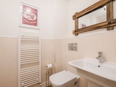 A bathroom with a toilet sink radiator mirror and a framed picture at Stone's Throw in Charlestown