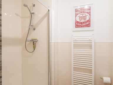 A bathroom with a shower area towel radiator and framed wall art at Stones Throw in Charlestown