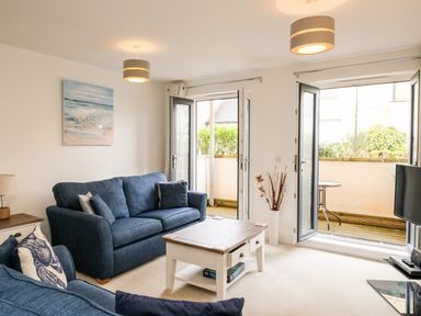A living room with blue sofas and a white coffee table with drawers at Stone's Throw in Charlestown