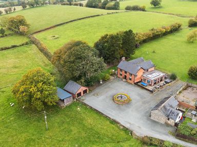 An aerial view of a house with gardens and fields at Bwthyn Ty Newydd in Llangadfan