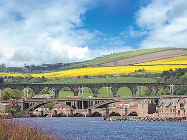 A river with three bridges crossing it and hills with fields in the background at The Lookout in Berwick-upon-Tweed