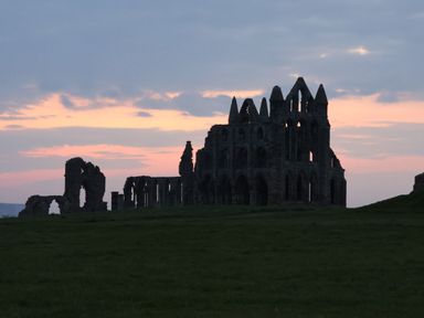 Ruins of an abbey under a cloudy sky at Mayfield Manor Whitby
