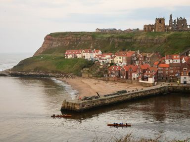 A view of houses by the water with boats at Mayfield Manor in Whitby