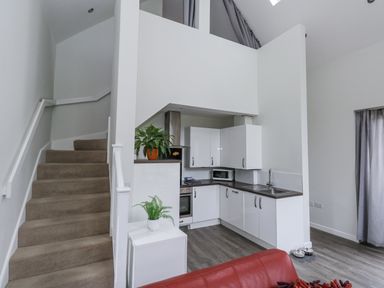 A kitchen with a staircase and seating area at Budmouth in Upwey near Weymouth