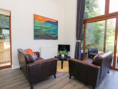 A living room with sofas and a television at Shepherd Oak in Upwey near Weymouth