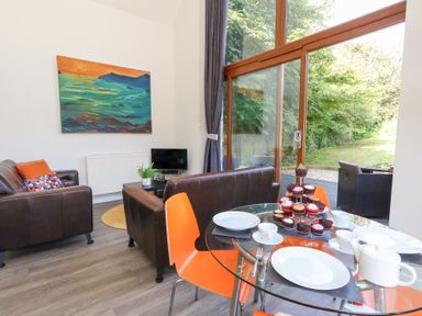 A living room with a dining table and cupcakes at Shepherd Oak in Upwey near Weymouth