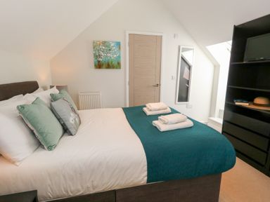 A bedroom with a bed and towels on it at Shepherd Oak in Upwey near Weymouth
