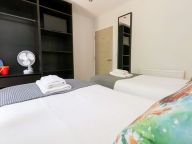 A bedroom with two beds and a fan at Shepherd Oak in Upwey near Weymouth