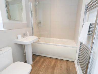 A bathroom with a bathtub and sink at Shepherd Oak in Upwey near Weymouth