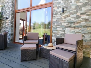 An outdoor seating area with chairs and a table at Shepherd Oak in Upwey near Weymouth