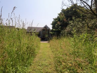 A pathway leading to a house surrounded by grass at Shepherd Oak in Upwey near Weymouth