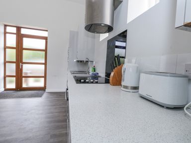A kitchen featuring a sink, cooktop, and various appliances at Everdene Upwey near Weymouth