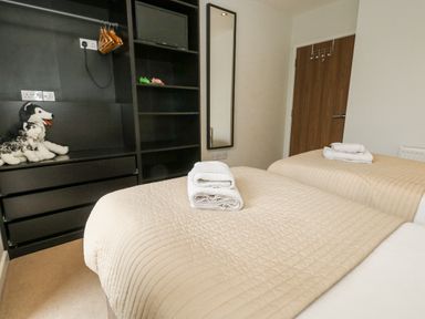 A bedroom with twin beds and a mirror at Everdene in Upwey near Weymouth