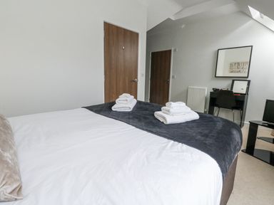 A bedroom with a bed and desk at Everdene in Upwey near Weymouth