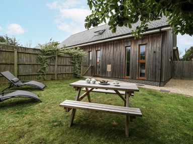 A garden with a picnic table and deck chairs at Everdene Upwey near Weymouth