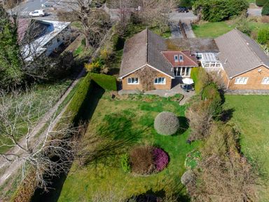 Aerial view of two adjacent houses with gardens and trees at Trederwen in Rhayader