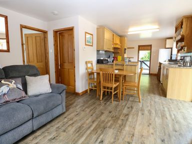 A kitchen with dining table and chairs at Dragonfly Lodge in Whinburgh near Dereham