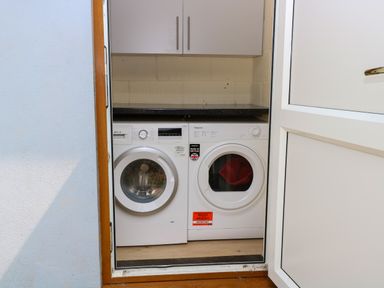 A laundry room with a washing machine and dryer at Dragonfly Lodge Whinburgh near Dereham