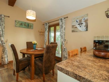 A dining room with a wooden table and chairs at Valley View Lodge Welshpool