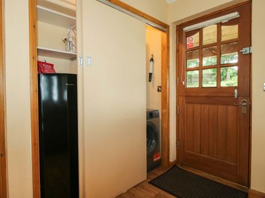A laundry room with a fridge and washing machine at Valley View Lodge in Welshpool