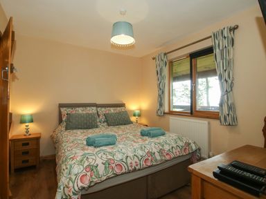A bedroom with a bed and two bedside tables at Valley View Lodge in Welshpool
