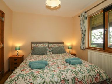 A bedroom with a double bed and lamps at Valley View Lodge in Welshpool