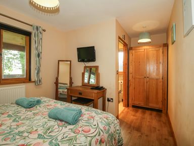 A bedroom with a bed and a mirror at Valley View Lodge Welshpool