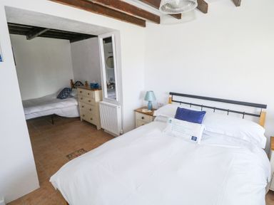 A bedroom with a double bed and a smaller bed in an adjacent space at Dun na Ron in Oughterard County Galway
