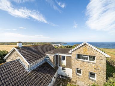 A house with a view of the ocean and landscape at Tregiffian Vean Sennen Cove