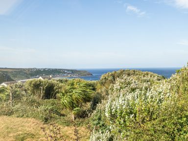 A coastal view with plants and houses at Tregiffian Vean in Sennen Cove