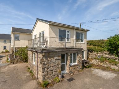 A house with a balcony and stone wall at The Lookout in Sennen