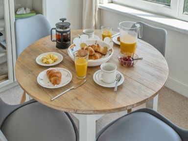 A dining room with a table set for breakfast at The Lookout in Sennen