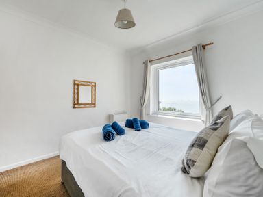 A bedroom with a bed and towels at The Lookout in Sennen