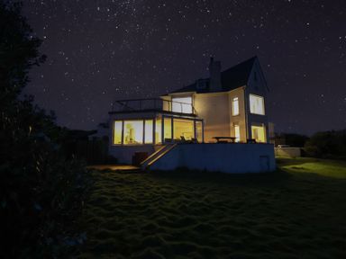 A house with illuminated windows at night at Carn Eve in Sennen Cove near St Just