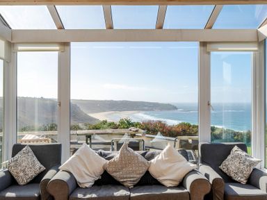 A conservatory with a glass wall and ocean view at Carn Eve in Sennen Cove near St Just