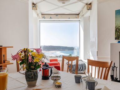 A dining room with flowers on a table at Carn Eve Sennen Cove near St Just