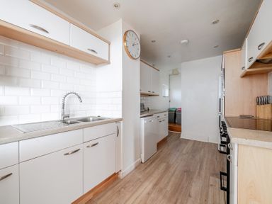 A kitchen with cabinets, sink, and stove at Carn Eve Sennen Cove near St Just