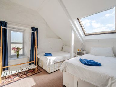 A bedroom with two beds and a window at Carn Eve in Sennen Cove near St Just