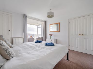 A bedroom with a bed and a table at Carn Eve in Sennen Cove near St Just