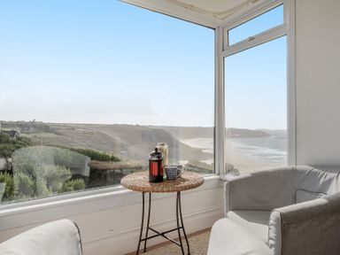 A seating area with a table and window view at Carn Eve in Sennen Cove near St Just
