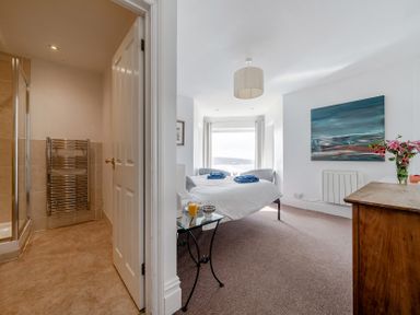 A bedroom with a bed and shower at Carn Eve in Sennen Cove near St Just