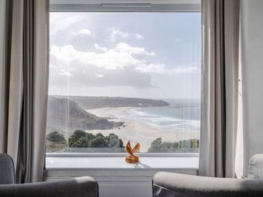A living room with a view of the beach at Carn Eve in Sennen Cove near St Just