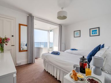 A bedroom with two beds and breakfast tray at Carn Eve in Sennen Cove near St Just