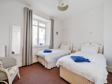 A bedroom with two beds and a mirror at Carn Eve Sennen Cove near St Just