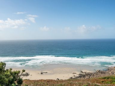 A view of the ocean and beach with waves at Carn Eve Sennen Cove near St Just