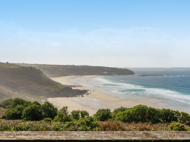 A view of a beach with waves and hills at Carn Eve Sennen Cove near St Just