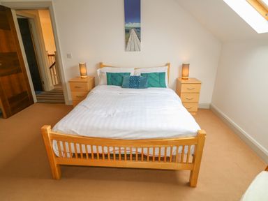 A bedroom with a wooden bed and two nightstands with lamps in Millers Lane House Muff County Donegal