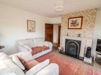 A living room with sofas a fireplace and a television at Millers Lane House in Muff County Donegal