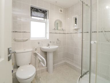 A bathroom with a toilet sink shower and window at Sycamores Rosecraddoc Lodge near Liskeard