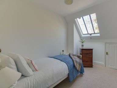 A bedroom with a single bed a wooden bedside cabinet and a skylight window at The Old School House in Piddletrenthide
